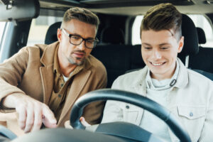 Parent teaching teenager how to drive